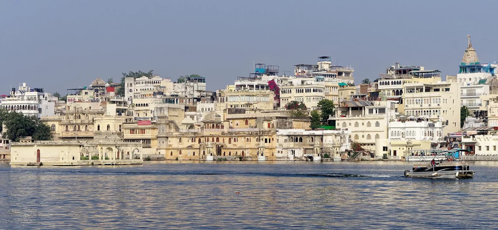 Buildings and a boat along Lake Pichola in Udaipur